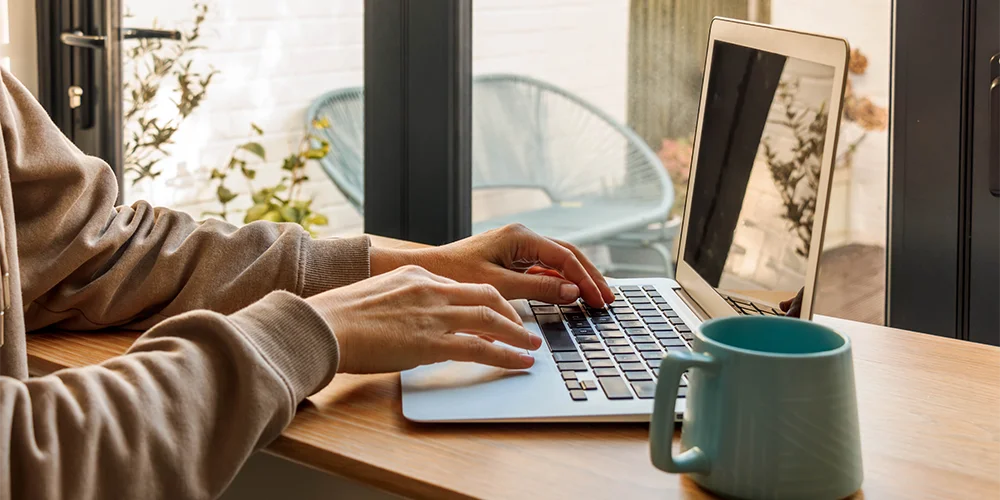 Externe Abschlussarbeit schreiben: Diese Dinge solltest du beachten / MLP Financify / Student am Laptop