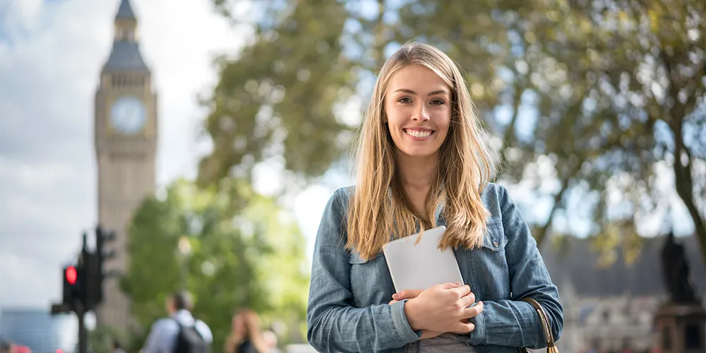 Mit BAföG im Ausland studieren / MLP Financify / Studentin läuft glücklich mit Unterlagen im Arm durch London