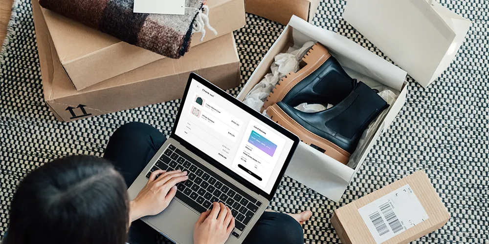 Buy now, cry later / MLP Financify / Person mit Laptop und herumliegenden Paketen