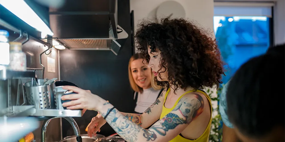 Leben in einer funktionalen WG / MLP Financify / Mitbewohnerinnen kochen zusammen in einer funktionalen WG.