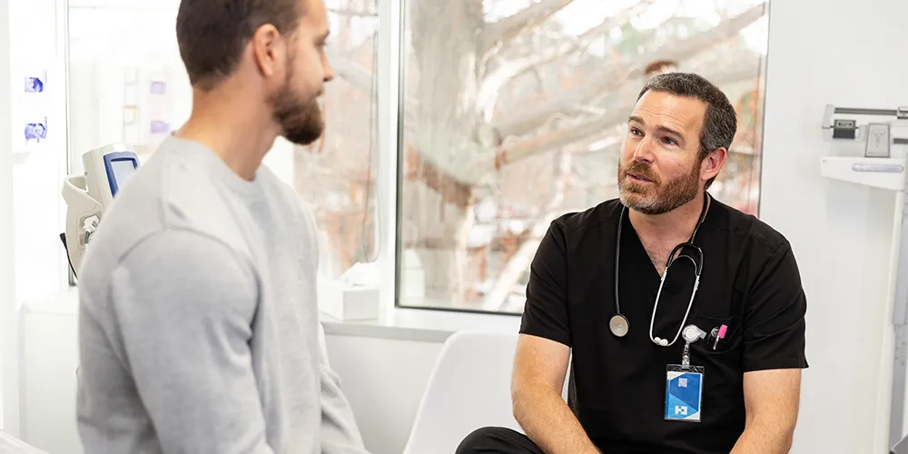 Regelmäßige Gesundheitschecks | MLP financify | Arzt und junger Patient im Gespräch