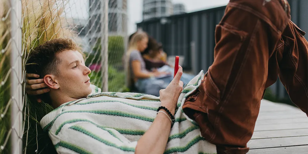 Produktiv lernen trotz Hitze / MLP Financify / Student entspannt im Sommer draußen mit Handy