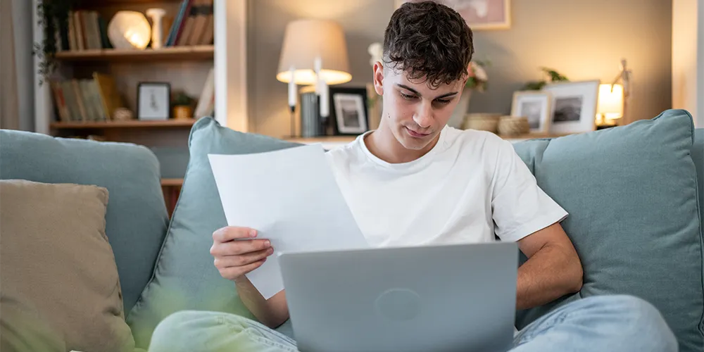 Lernvorsätze Studium / MLP Financify / Student bei der Semesterplanung auf dem Sofa.