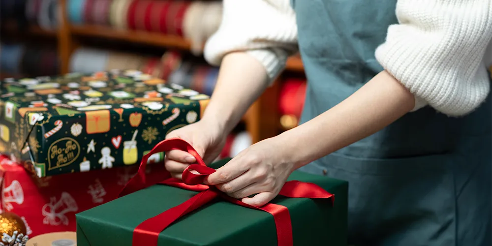 Studentenjob Weihnachten / MLP Financify / Aushilfe Weihnachtsgeschäft verpackt Geschenke.