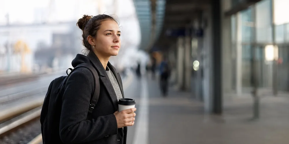 Pendlerpauschale 2026 / MLP Financify / Junger Berufseinsteiger am Bahnhof auf dem Weg zur Arbeit.
