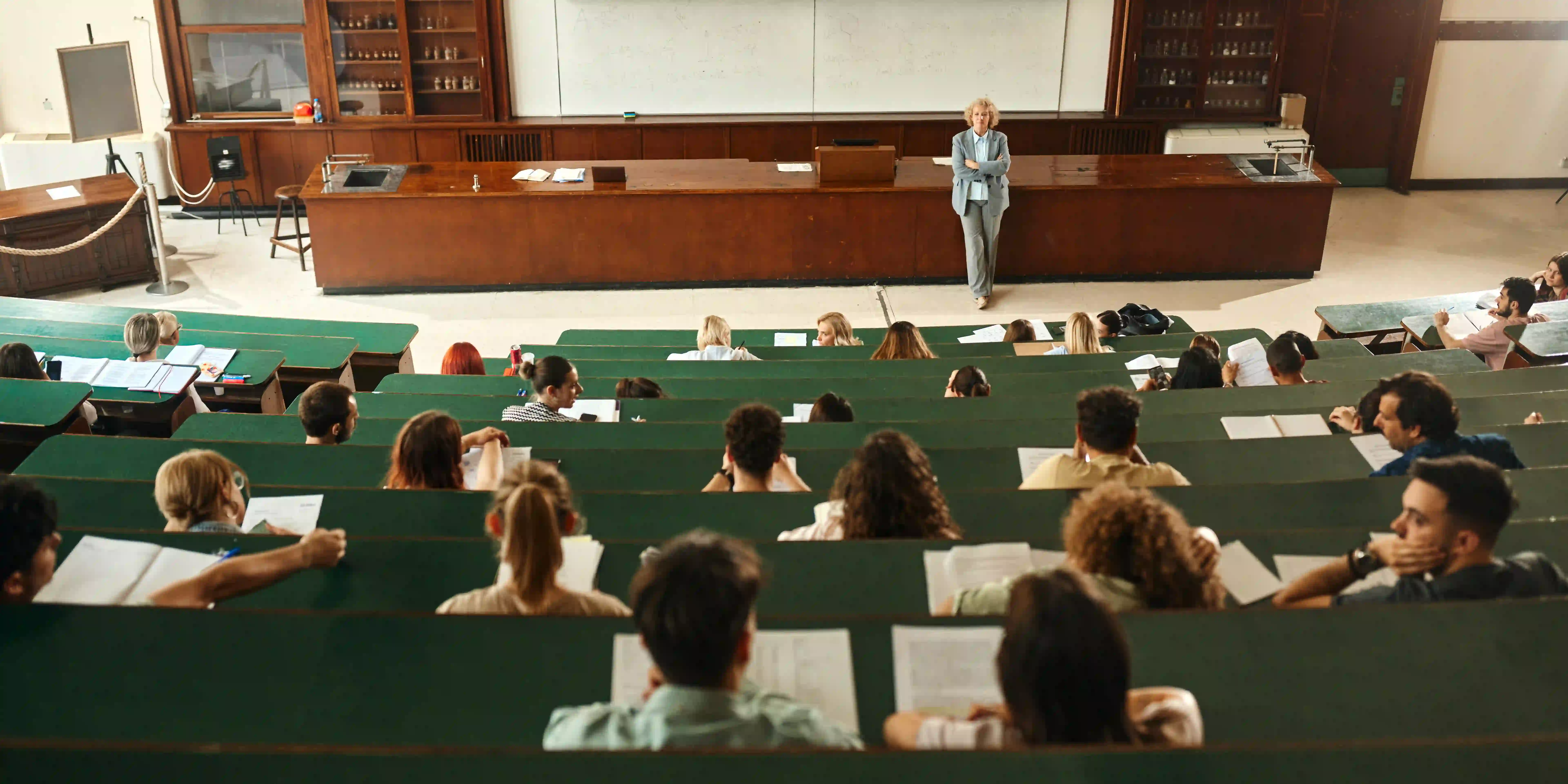 Das Gehalt als Professor*in: Was verdient man und wie kommt man an den Professorenjob? / MLP Financify / Professor steht in einem Vorlesungssaal in der Universität