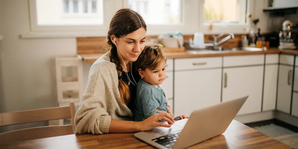 Studium mit Kind / MLP Financify / Studentin lernt am Laptop mit ihrem kleinen Sohn auf dem Schoß.