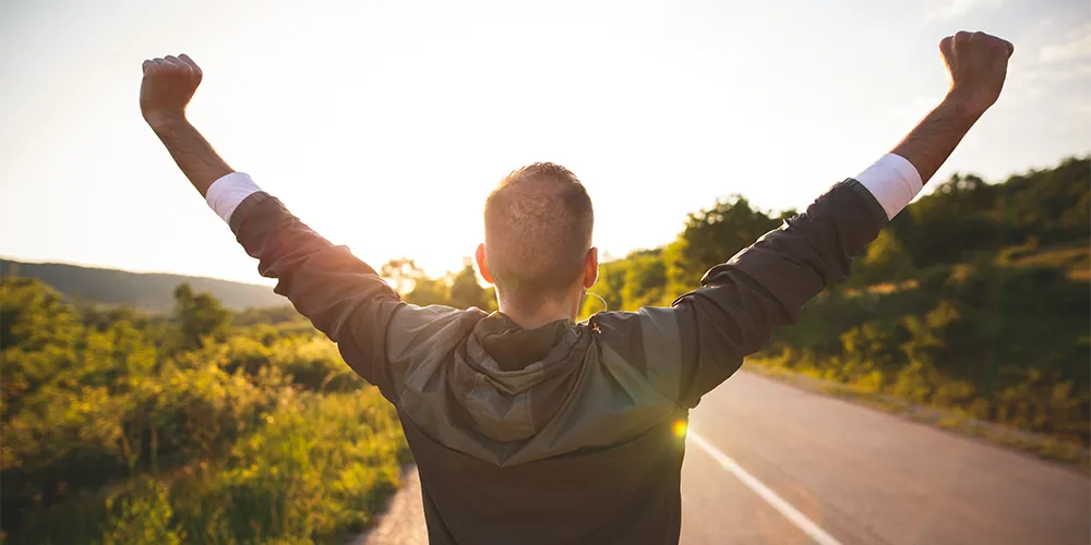 Eine Person streckt freudig die Fäuste in den Himmel.