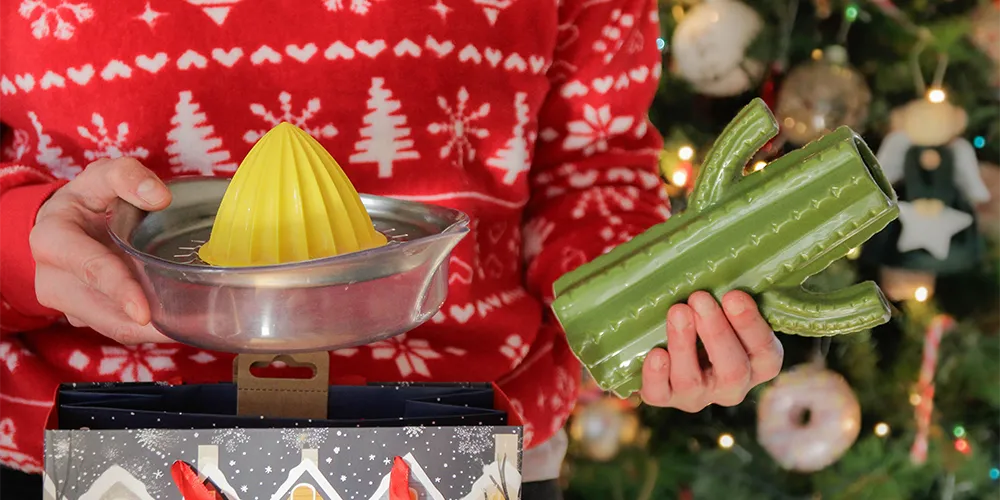 Weihnachtsgeschenke umtauschen: So gehst du richtig vor / MLP Financify / Student hält Geschenke in der Hand, die er umtauschen möchte
