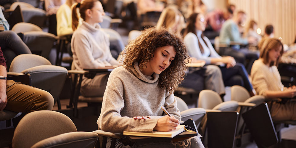 Zweitstudium: Wie läuft die Bewerbung und fallen Gebühren an? / MLP financify / Studentin im Hörsaal